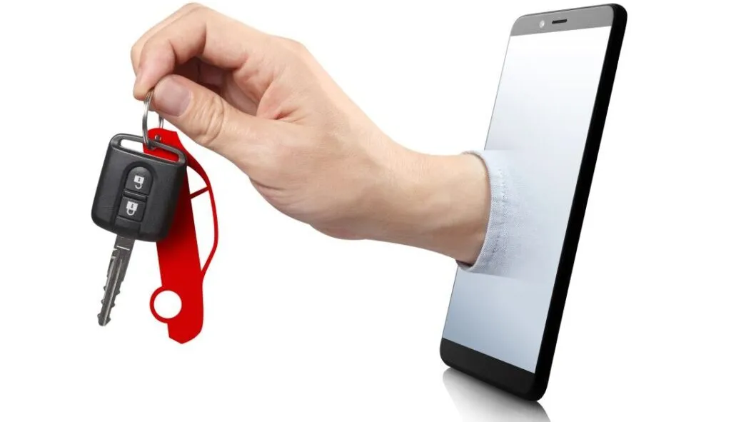 Hand reaching through a smartphone screen offering car keys with a red keychain